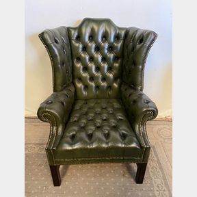 A FINE GREEN LEATHER BUTTON WING BACKED ARM CHAIR, raised on square leg, the leather with nice brass bead trim