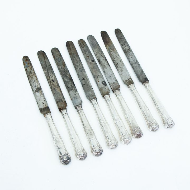 Eight steel-bladed dinner knives