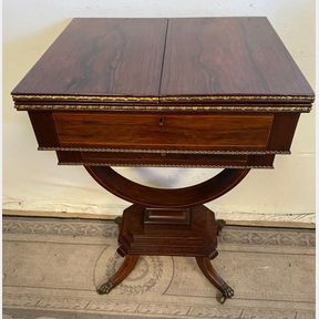 A FINE REGENCY ROSEWOOD FOLD OUT TABLE, with two leaves to the top that fold outwards to create a wide table s