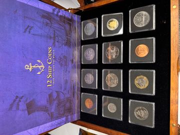 12 SHIP COINS FROM AROUND THE WORLD IN WOODEN CASE