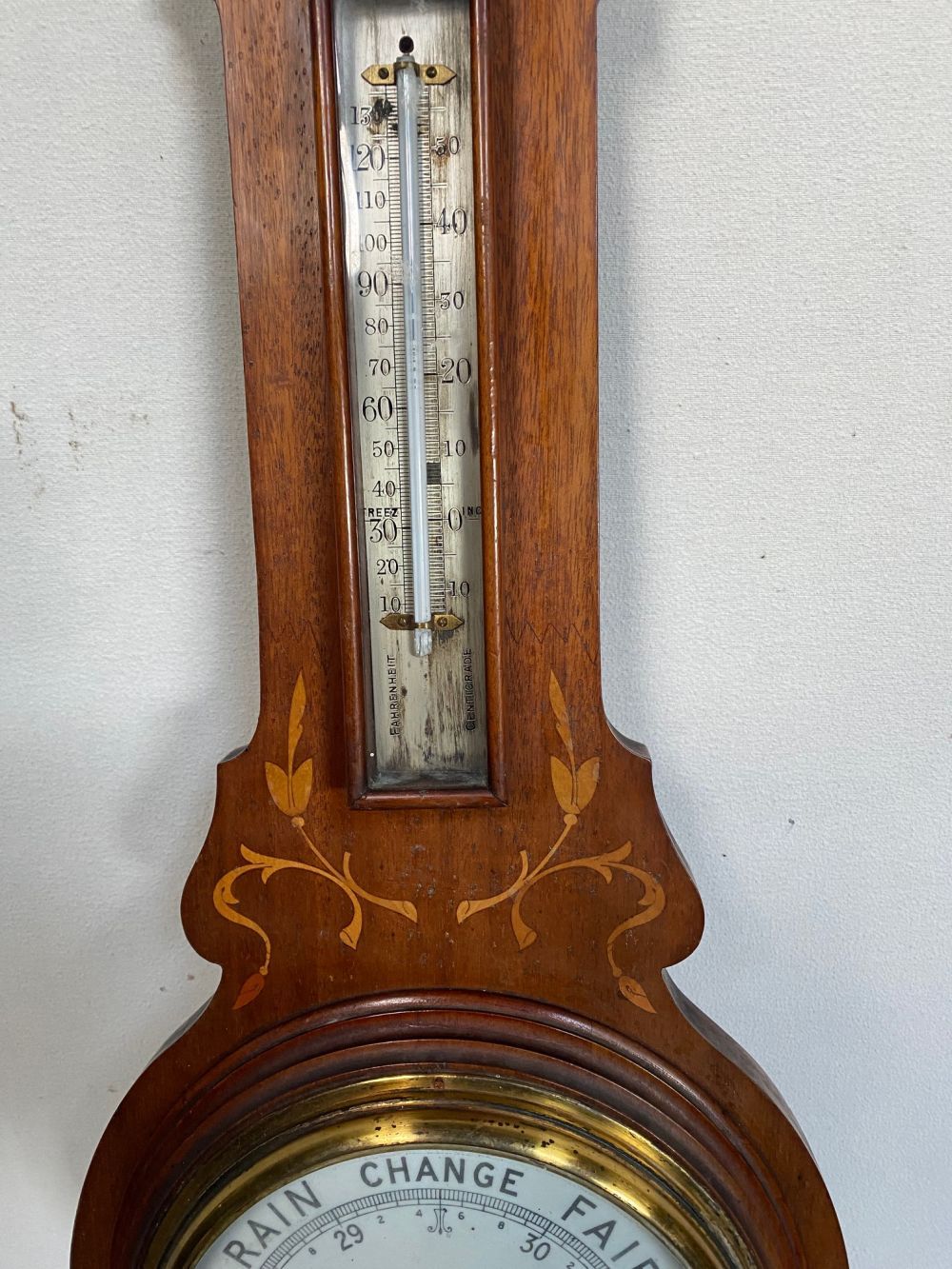 A MARQUETRY INLAID MAHOGANY ANEROID BAROMETER, dial reading ‘Stormy