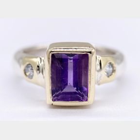 3CT PURPLE AMETHYST WITH 0.20CT DIAMONDS SET IN THE BAND IN 9CT YELLOW GOLD.7.7G