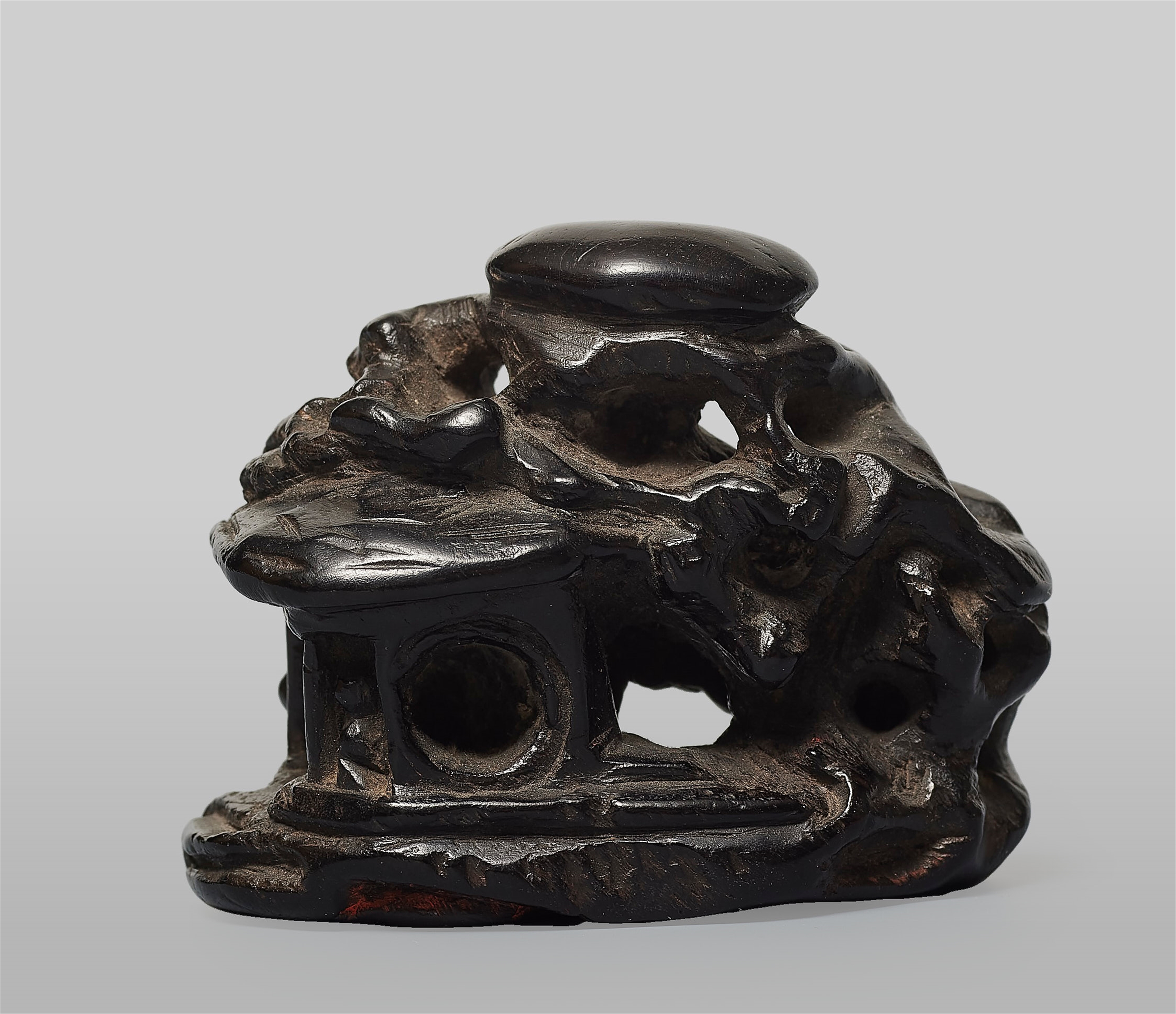 A black wood seal netsuke of a mountainous landscape. 19th century