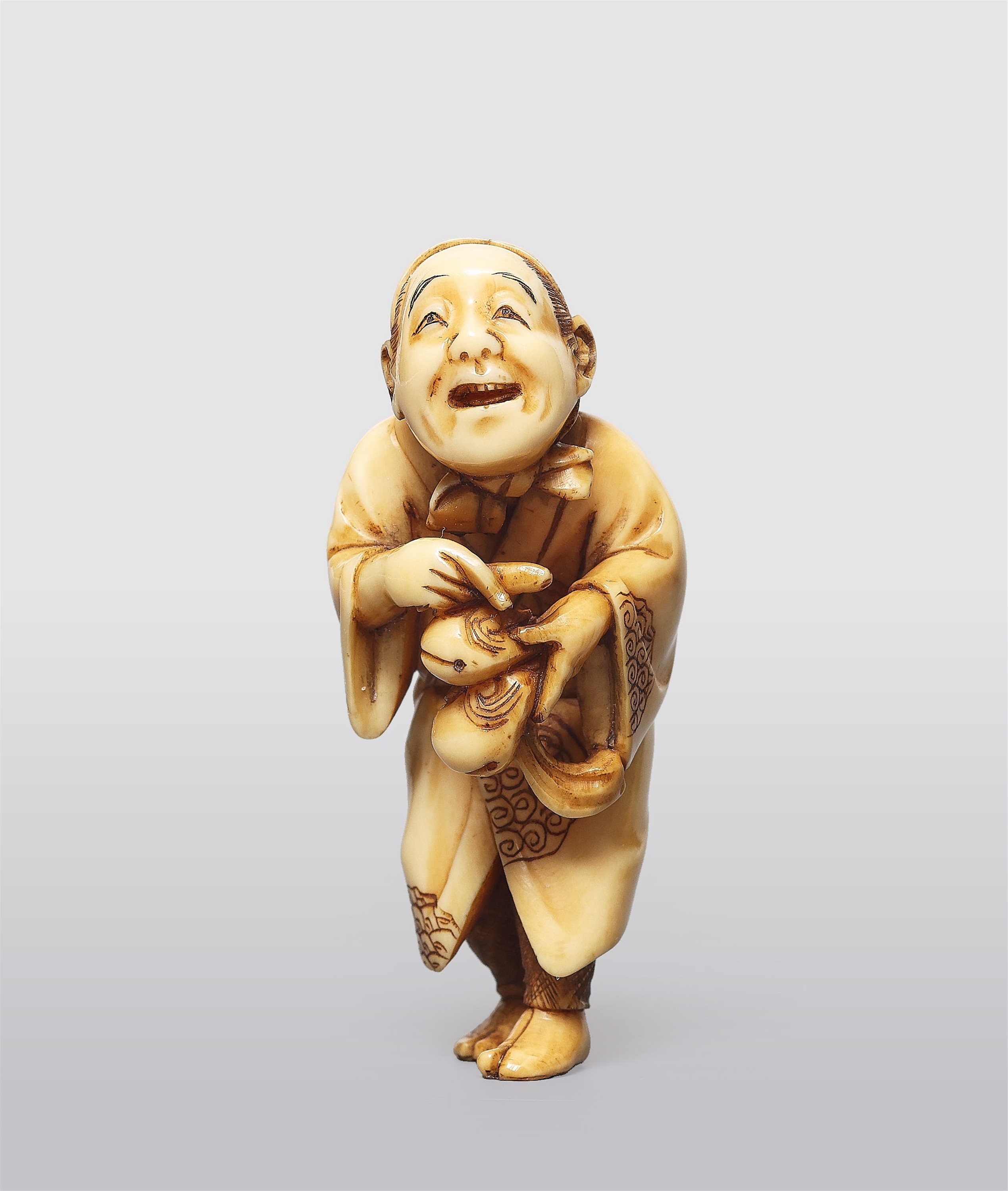 An ivory netsuke of a chanting entertainer by Kogyoku. Late 19th century