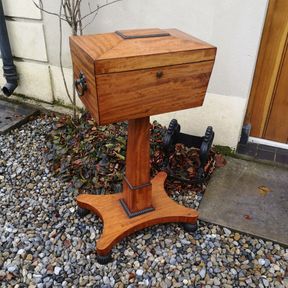 A STRIKING REGENCY SATINWOOD TEAPOY, the tea chest top with tapered body and ring handles to the sides opens t