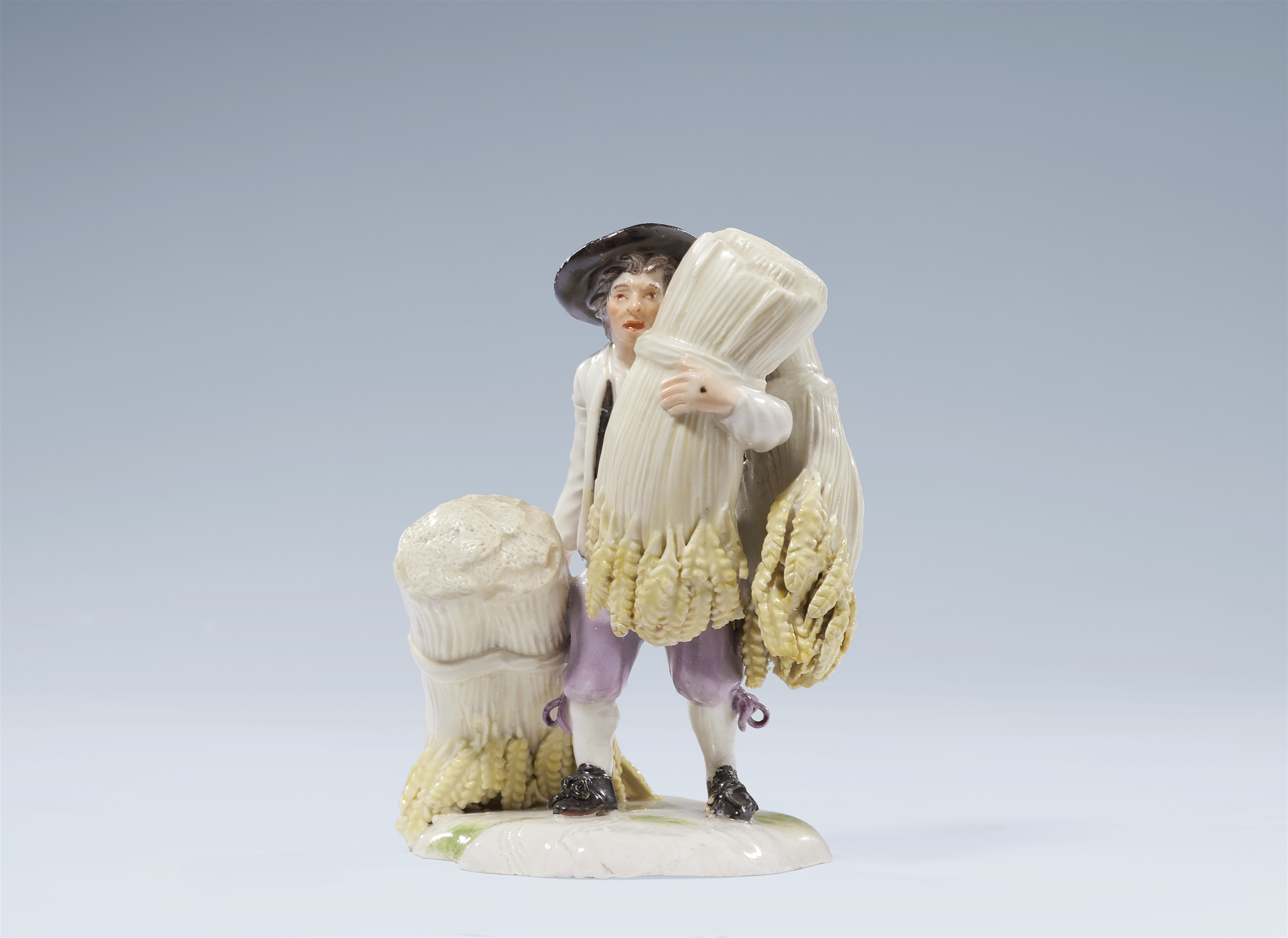 A Ludwigsburg porcelain figure of a peasant carrying wheat