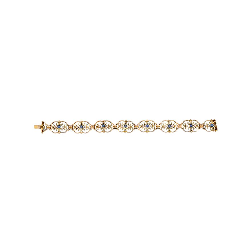 An Edwardian gold articulated bracelet inset with sapphires and seed pearls in a fitted case, 17cm
