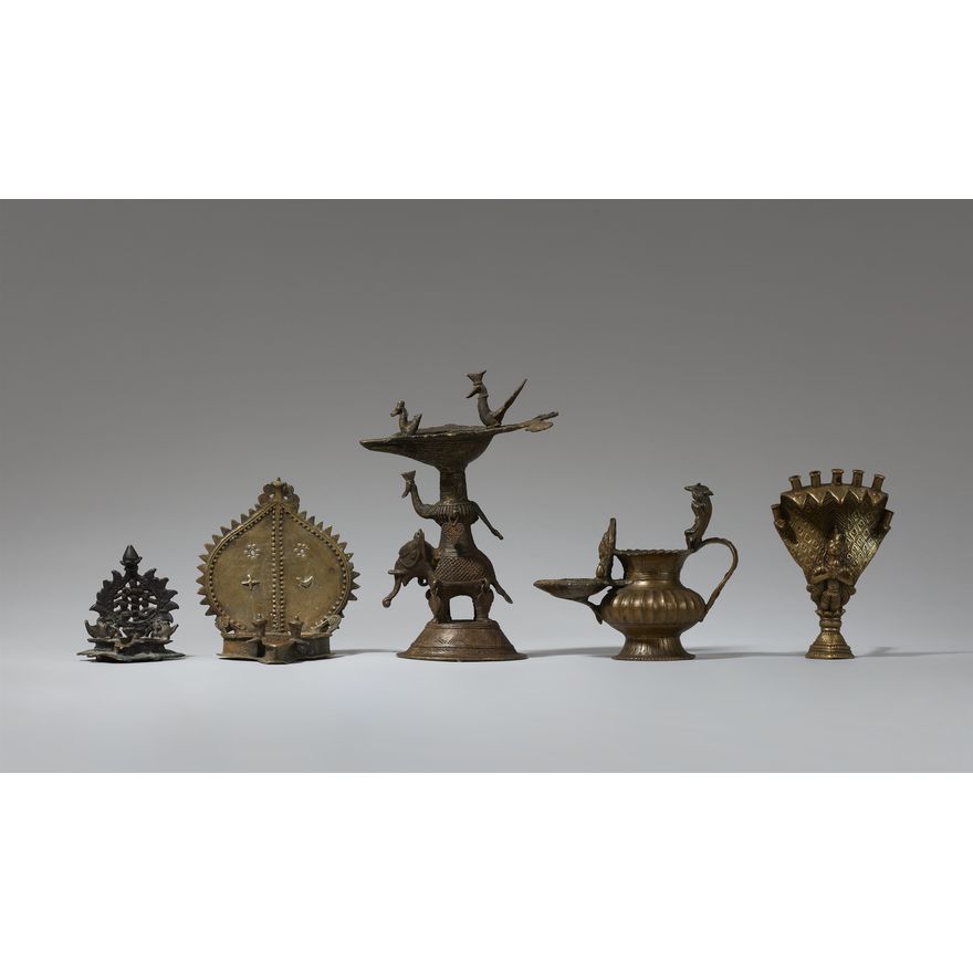 A group of four Indian copper alloy oil lamps and a holder for joss sticks. India. 19th/20th century