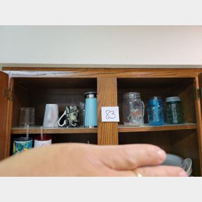 Shelf of various drinking glasses and canning jar
