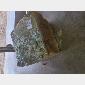 Chunk of stone.concrete with slag glass melted into it.