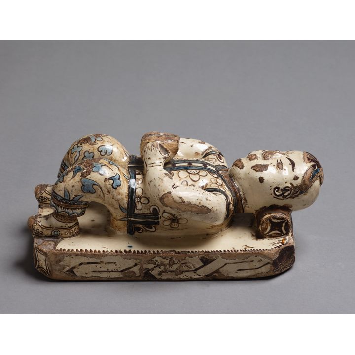 Decorative Chinese painted and glazed plaster figure of a child resting