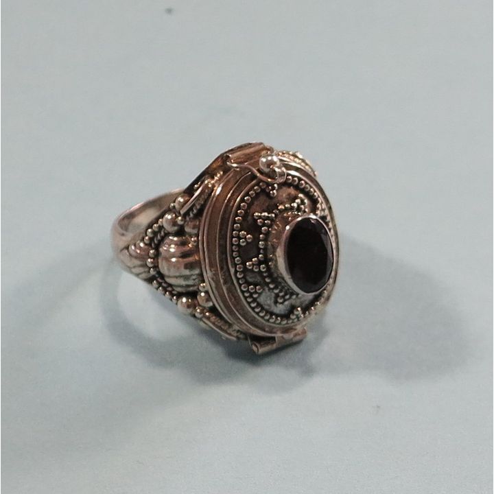 A STERLING SILVER AND GARNET POISON RING.