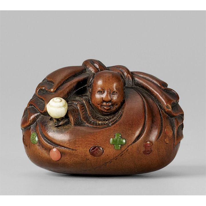 A boxwood netsuke of a karako in Hotei’s sack. Mid-19th century