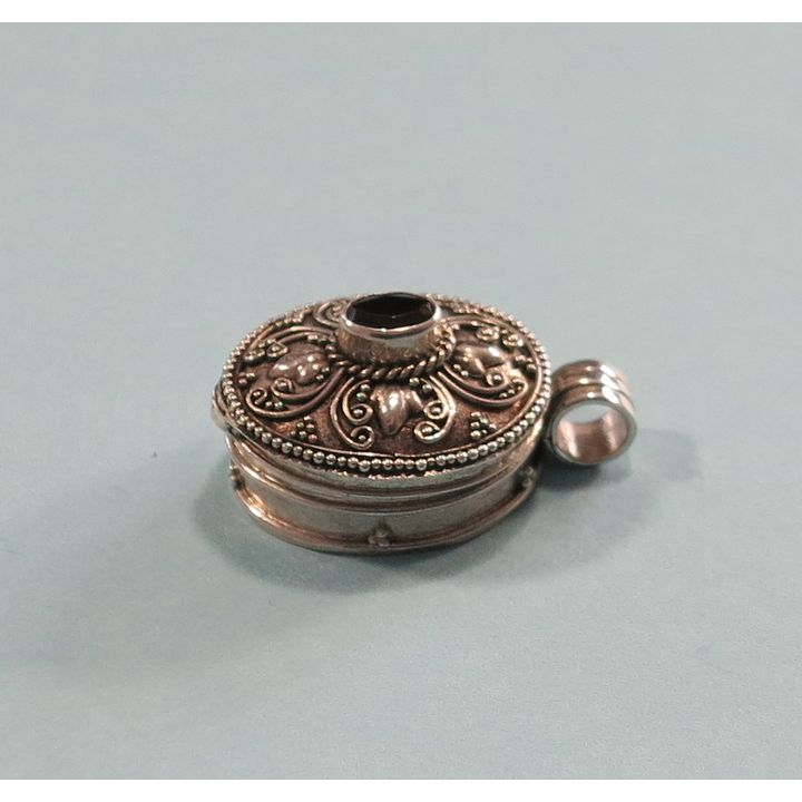 A STERLING SILVER AND GARNET LOCKET.