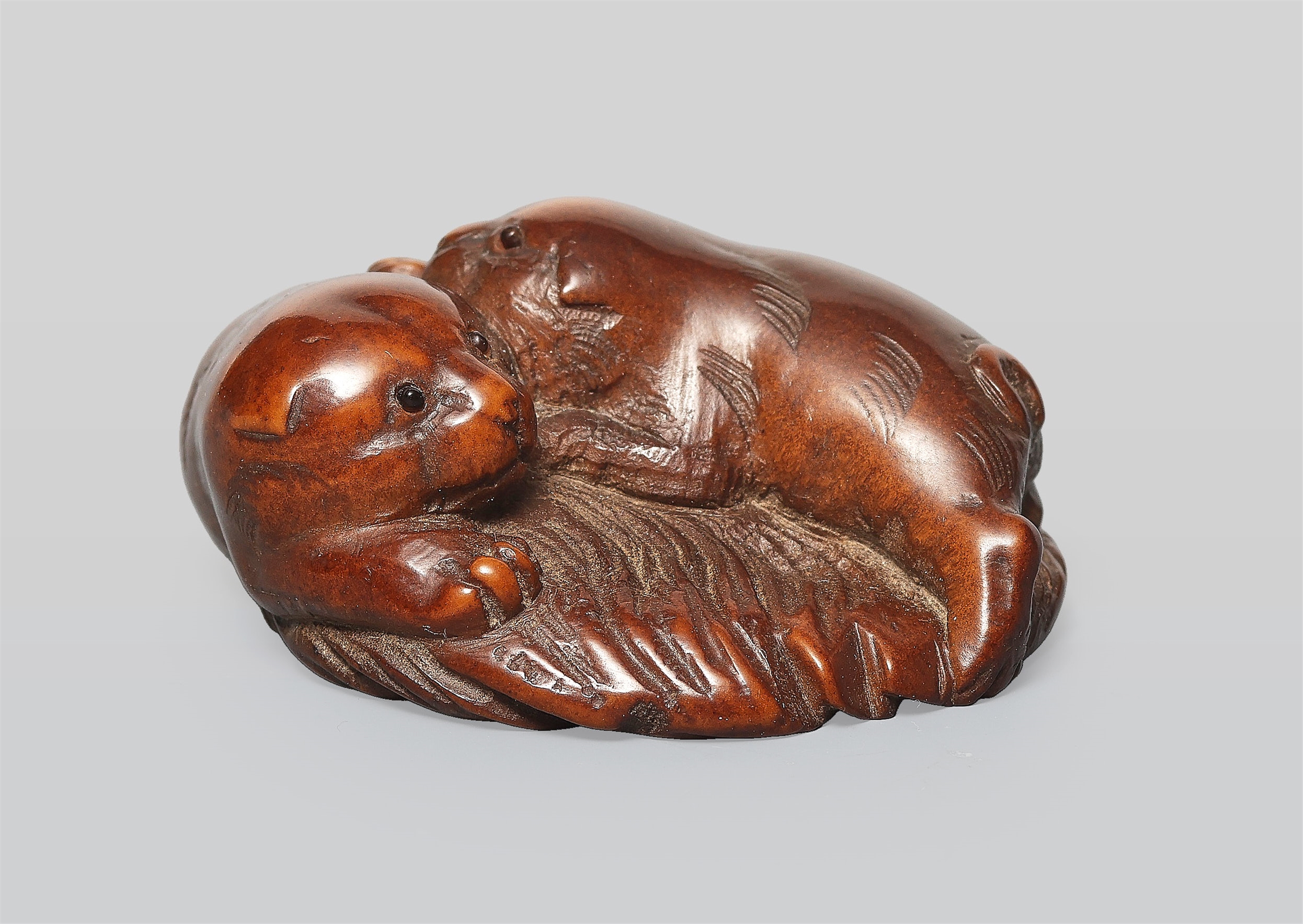A wood netsuke of two puppies. 19th century