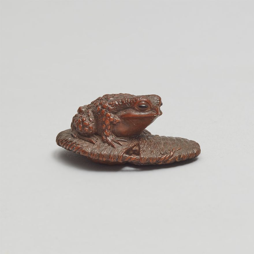 A small boxwood netsuke of a toad on a waraji. Ise. 19th century