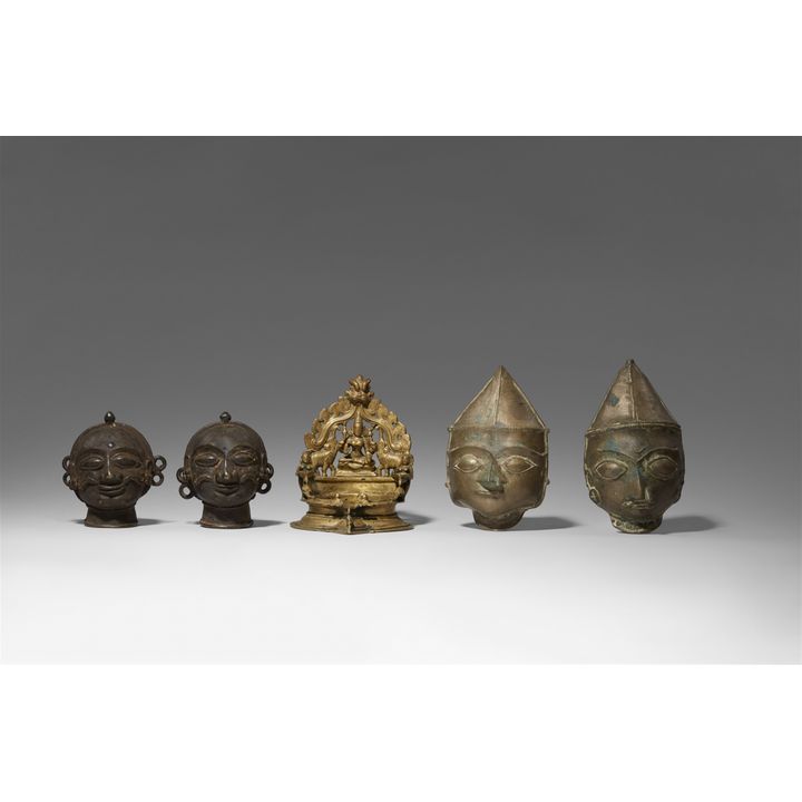 Four small Central Indian copper alloy masks and a lamp. Second half 19th/early 20th century