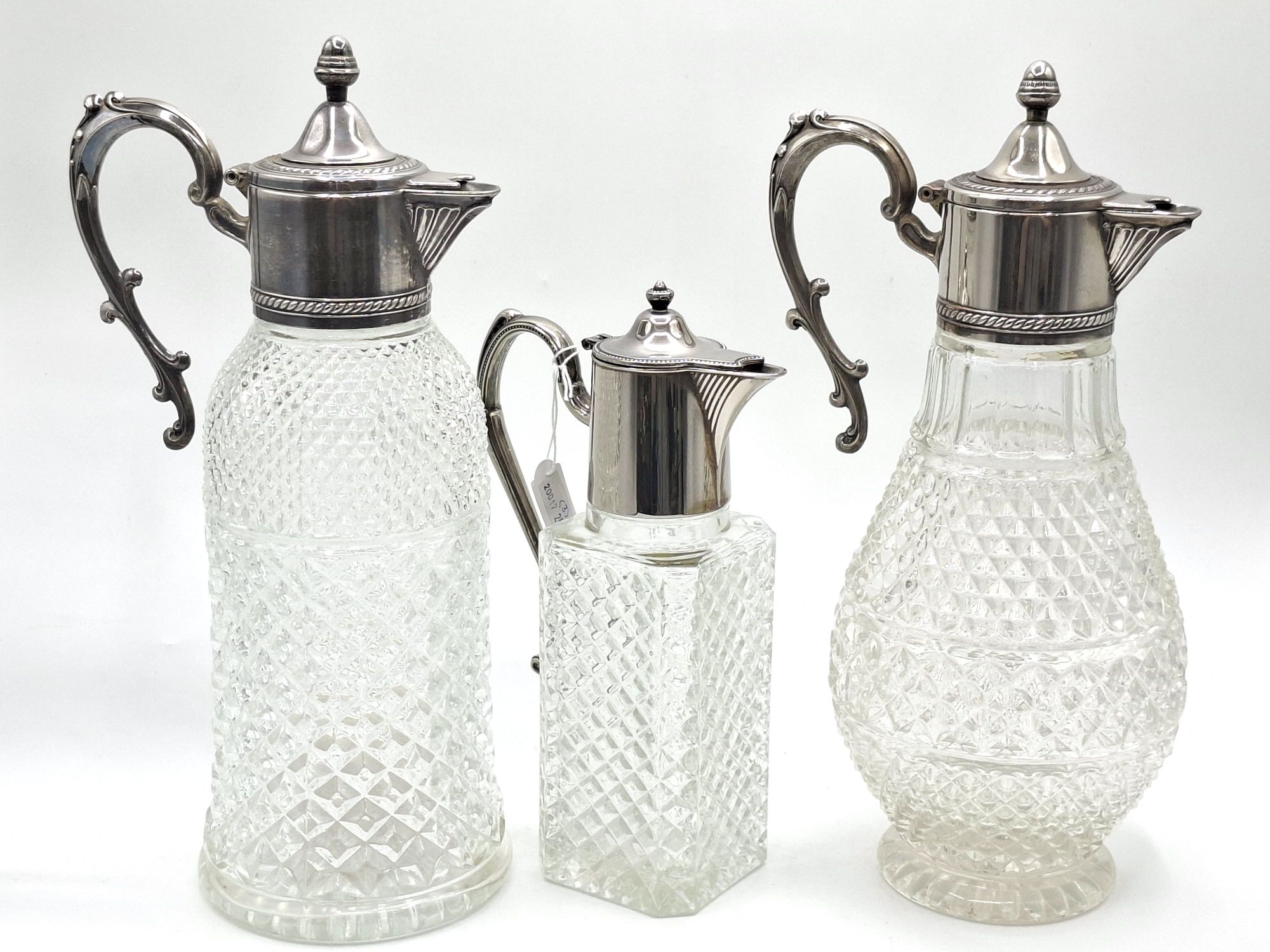 136 · THREE GLASS AND SILVERPLATED CLARET JUGS