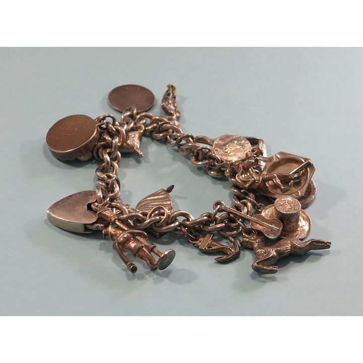 A HEAVY STERLING SILVER CURB-LINK CHARM BRACELET.