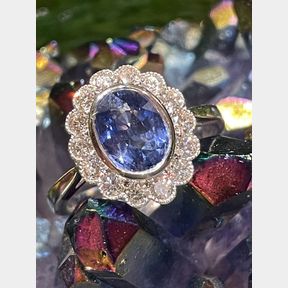 A VERY PRETTY 18CT WHITE GOLD CEYLON SAPPHIRE & DIAMOND RING, set in a millegrain setting, the beautiful Ceylo