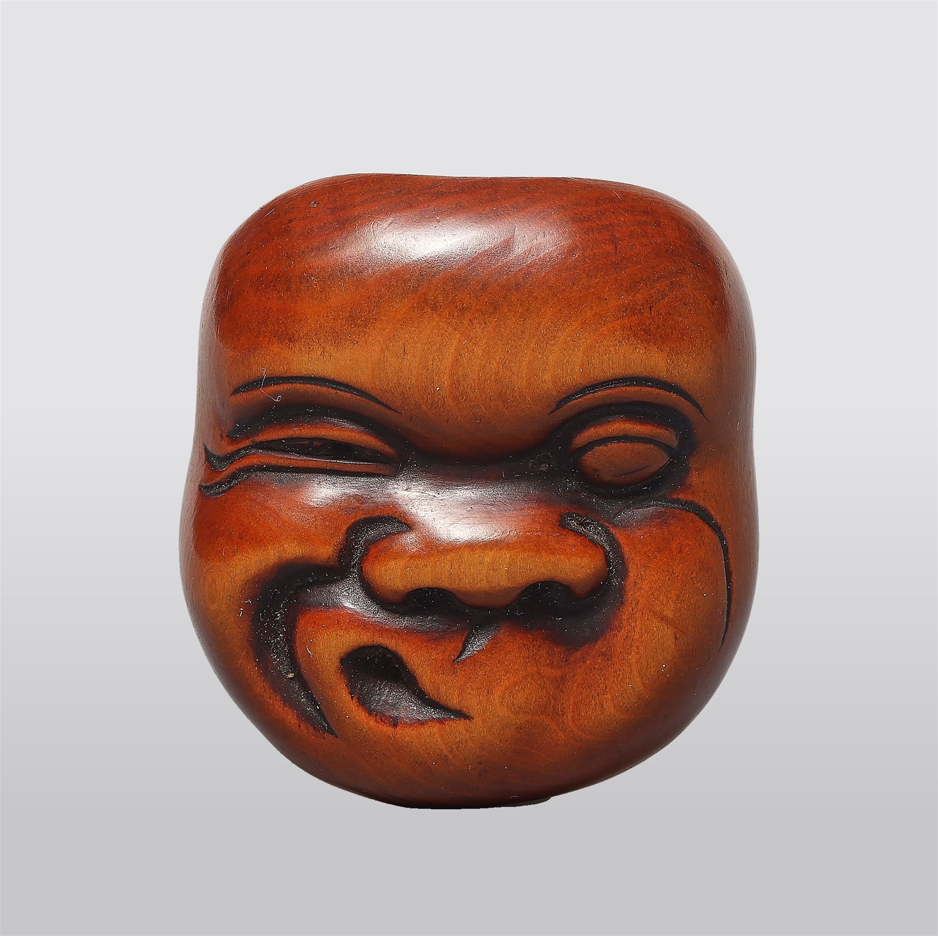 A boxwood netsuke of a Hyottoko mask. 19th century